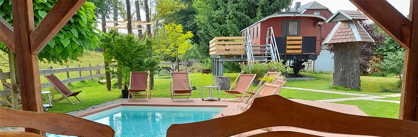 einen Pool und einen bewohnbaren Eisenbahnwaggon im Hof